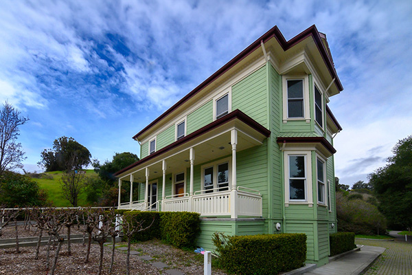 The Faria house exterior and a beautiful sky of clouds with vineyard in the front yard.