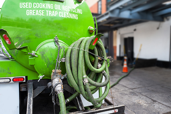 Used cooking oil recycling and grease trap cleaning from restuarant into grease storage truck.